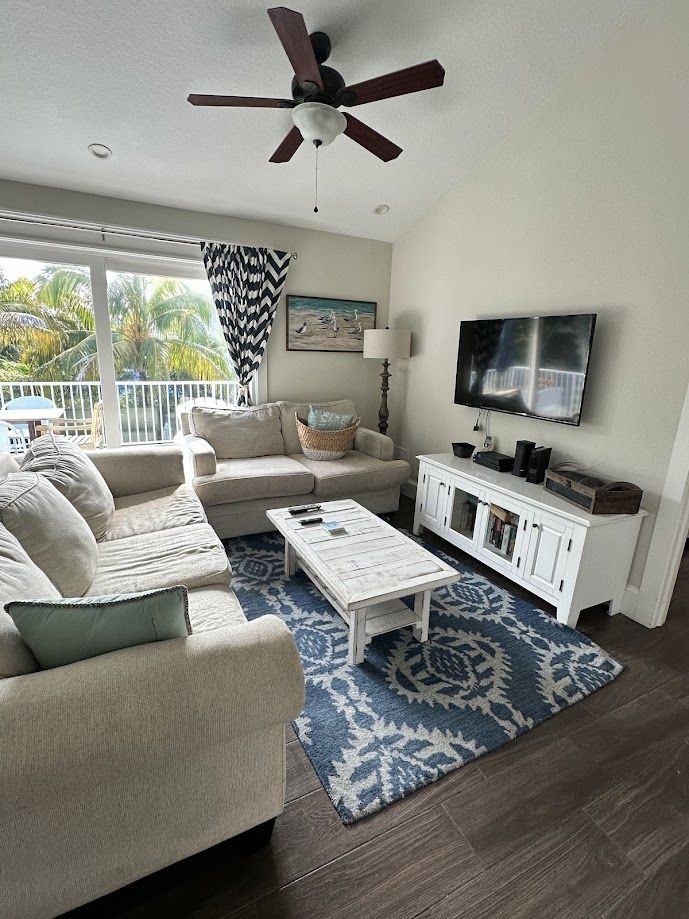 Freshly cleaned living room with sectional sofa and palm views from the balcony